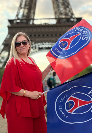 Karla Perrelli com bandeira do PSG em frente à Torre Eiffel