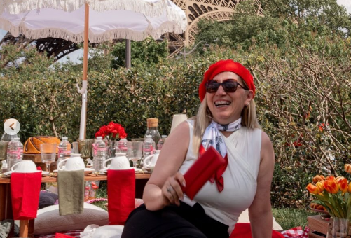 Karla Perrelli sorrindo durante um piquenique em Paris